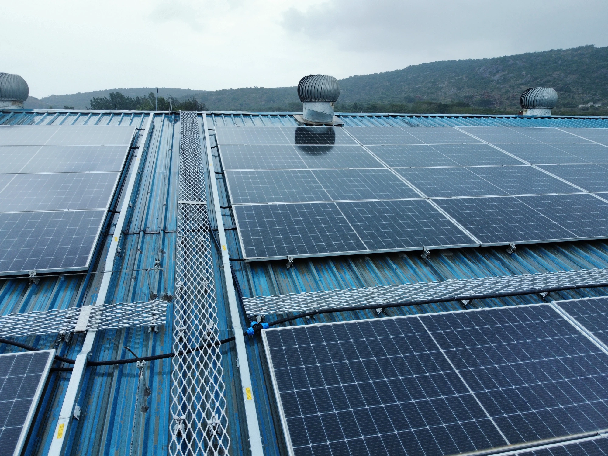 GJW Energy field installation — walkway mesh, safety lines and cable management on a rooftop array